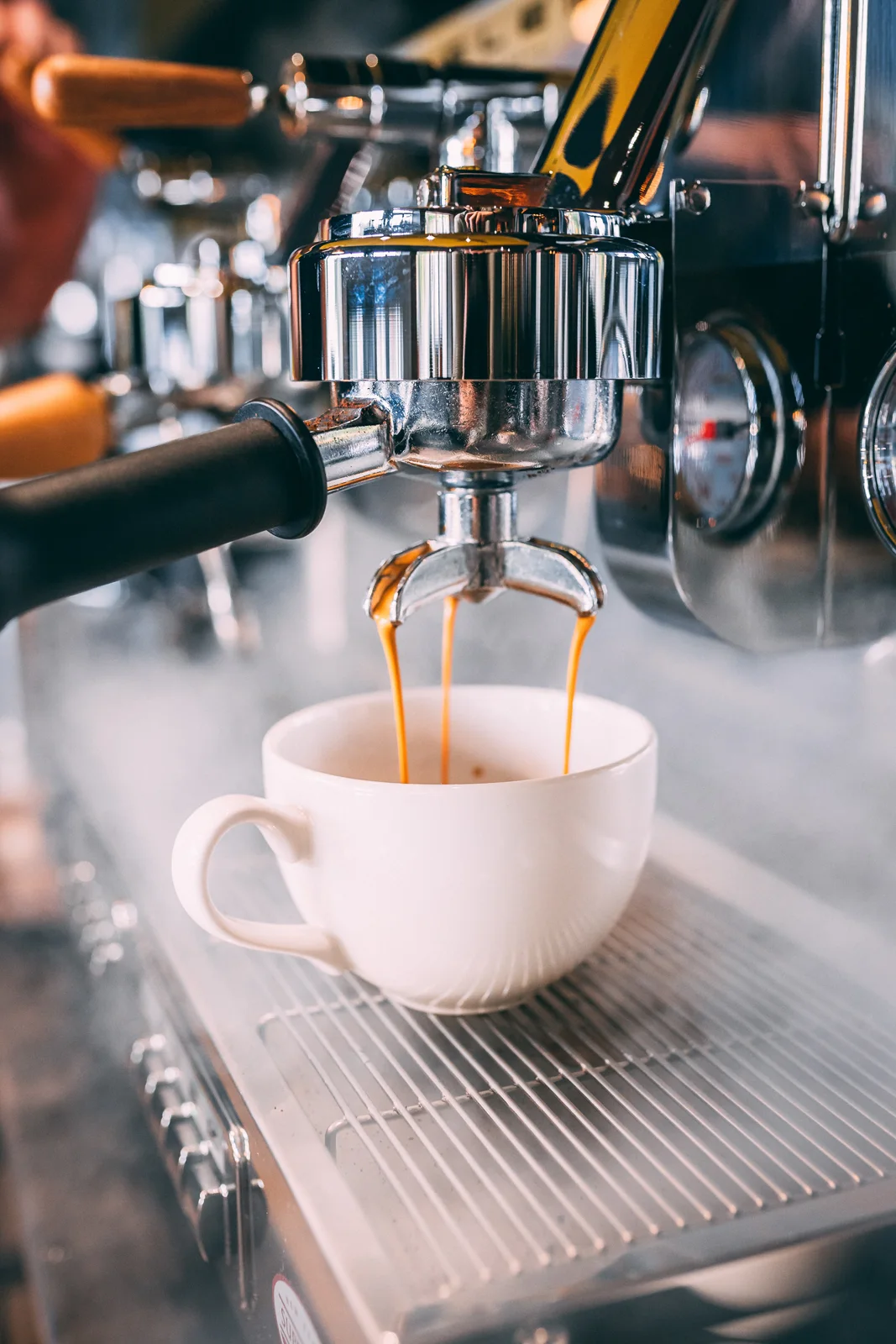 Espresso nalewane z ekspresu do białej filiżanki